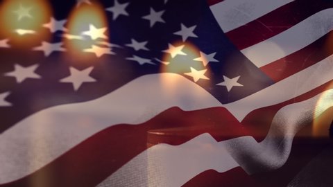 Animation of lit candles burning with a US flag billowing in the background