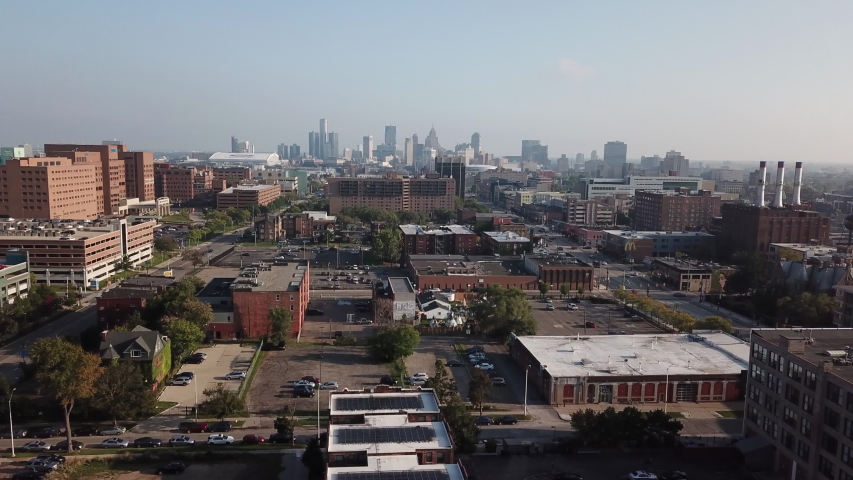 Aerial Drone Footage of Woodward Ave. Detroit museums, skyline and traffic visible on a beautiful sunny day. Public transportation, and people walking by on the city streets.