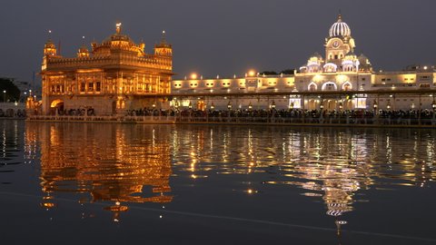a dusk shot of sikh pilgrims queued up at golden temple in amritsar, india