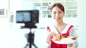 Young asian woman recording a movie of foods.