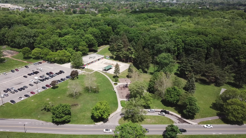 Aerial Drone Footage of Woodward Ave and Palmer Park. Detroit Skyline on a beautiful sunny day. Public transportation, and people walking by on the city streets. 