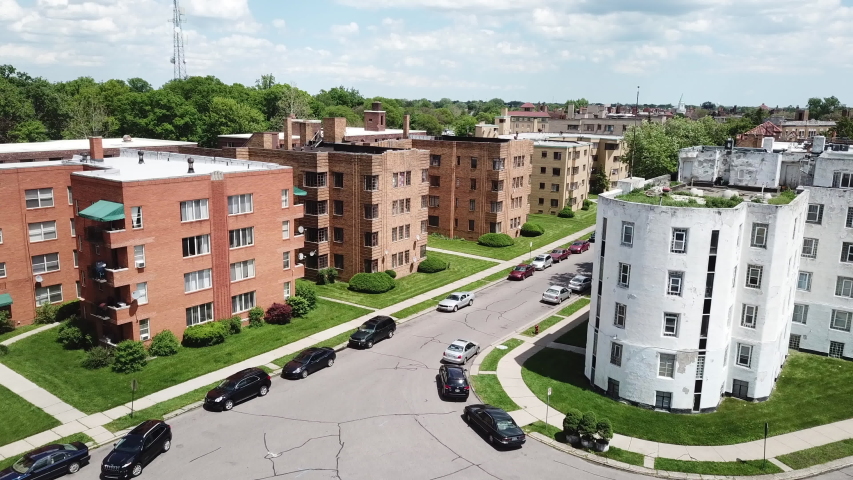 Aerial Drone Footage of Woodward Ave and Palmer Park. Detroit Skyline on a beautiful sunny day. Public transportation, and people walking by on the city streets. 