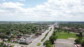 Aerial Drone Footage of Woodward Ave and Palmer Park. Detroit Skyline on a beautiful sunny day. Public transportation, and people walking by on the city streets. 