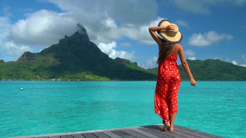 Travel influencer visiting famous destination on Bora Bora. Vacation woman on paradise motu beach on holidays in French Polynesia Girl on luxury travel in overwater bungalow resort hotel in Tahiti.
