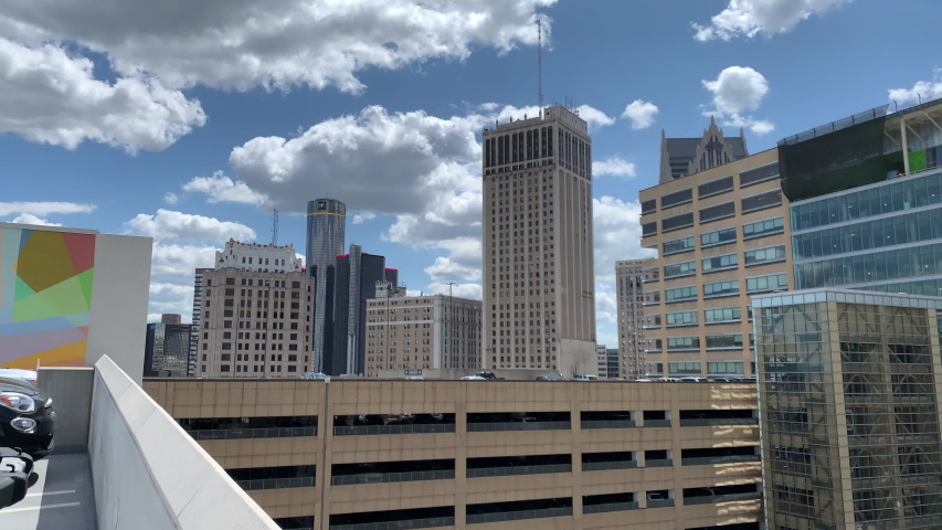 Aerial Drone Footage of Woodward Ave Detroit. Detroit skyline and traffic visible on a beautiful sunny day. Public transportation, and people walking by on the city streets.