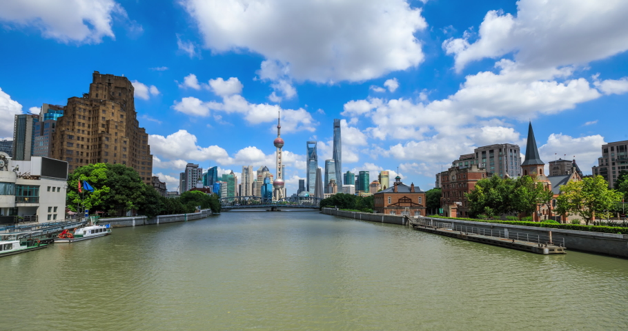 Time lapse of Shanghai skyline and cityscape on a sunny day,blue sky and white clouds fast moving landscape.