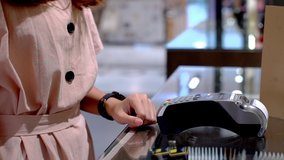 Young Asian woman using smartwatch to purchase product at the point of sale terminal in a retail store with near field communication nfc radio frequency identification payment technology - Powered by Shutterstock - Get 15% off with code: PIKWIZARD15