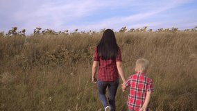happy family mom and son slow motion video concept. mother girl and son boy go lifestyle in nature to a field of sunflowers . happy family walk in nature