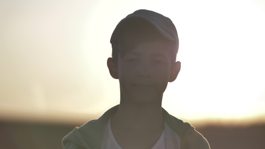 Portrait of a boy in a cap looking at the camera outdoors | Shutterstock HD Video #1038578240