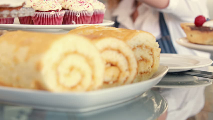 Pretty woman preparing plate of cakes in high quality 4k format