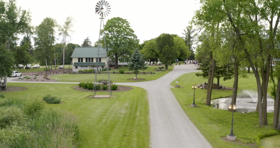 Long driveway revealing a beautiful farm house, pond, and barn in the country in Wisconsin