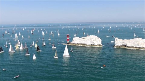 Aerial shot above many yachts & sailing ships on Isle of wight needles coast. Sailing ships view across vast open water.