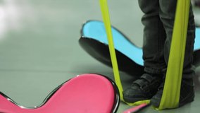 
A child testing a yellow pilates resistance band in a sports store, standing on the band and checking flexibility, balance, and durability. Fitness and active lifestyle, family shopping, and healthy  - Powered by Shutterstock - Get 15% off with code: PIKWIZARD15