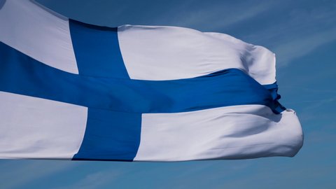 Finland flag detail close up in slow motion handheld movement on beautiful summer sky with thin clouds texture as background.
