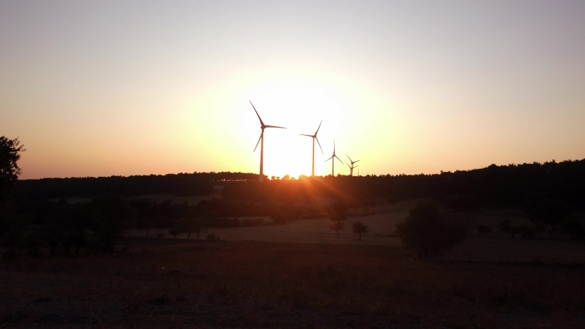 4K footage of renewable energy wind turbines on the mountain at sunset time