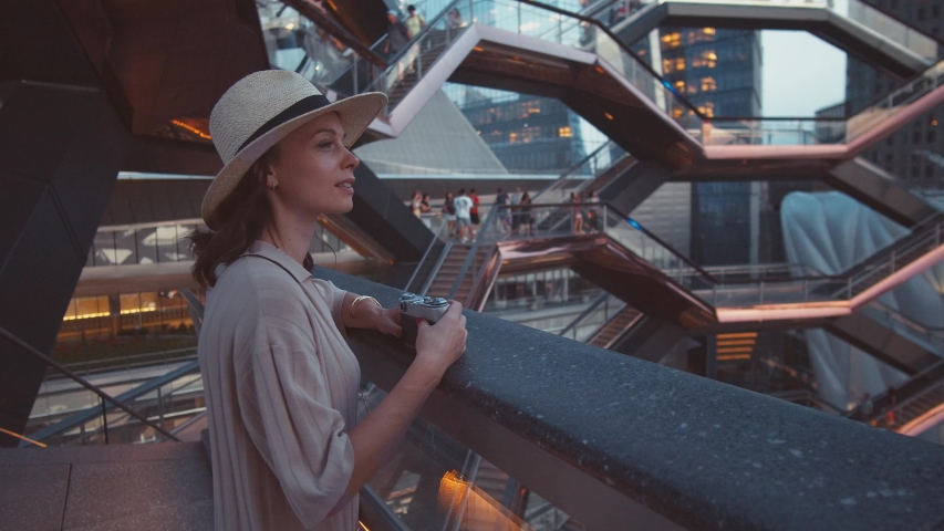 Attractive girl taking photo in the Wessel building. USA, 2019