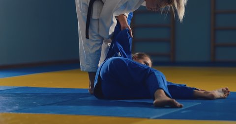 Fighters on the tatami. Judoka girls show wrestling techniques.