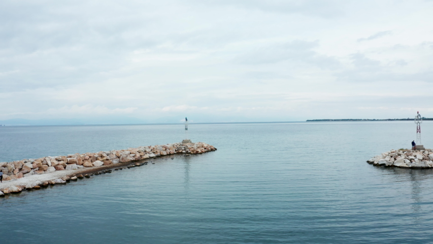 Drone flying over opern sea with blue water. Drone leaving docks.