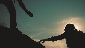 teamwork help business travel silhouette slow motion video concept. Helping hand silhouette between two climbers. teamwork group of tourists lends a helping hand climb the cliffs mountains. couple man