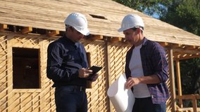 teamwork handshake. concept building constructing architect slow motion video. two men builder in helmets shake hands contract business contrast at a construction site. two workers in helmets shaking