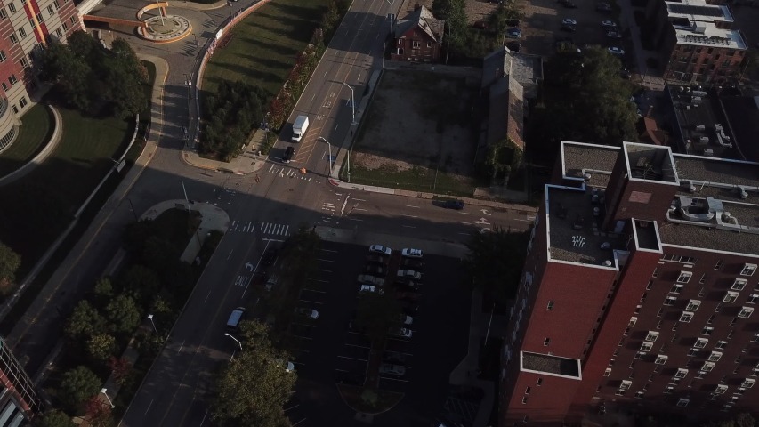 Aerial Drone Footage of Woodward Ave. Detroit museums, church, skyline and traffic visible on a beautiful sunny day. Public transportation, and people walking by on the city streets.