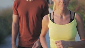Modern woman and man jogging / exercising in urban surroundings. Slow motion video.