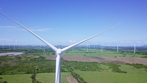 aerial view of wind turbine, trees, on sunny day