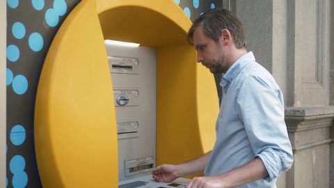 Close up of man's hand insert ATM card into Automated teller machine (Automatic banking machine) to withdraw cash money, Banking and Business Concept.