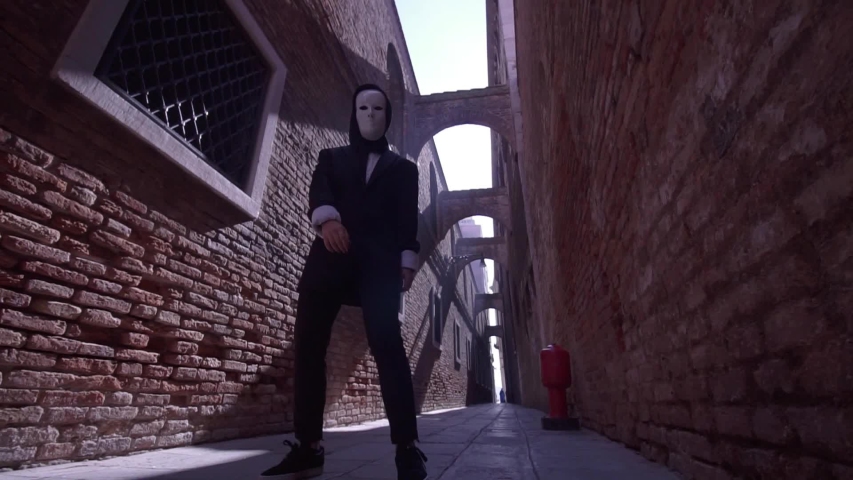 Masked person dances in Venice