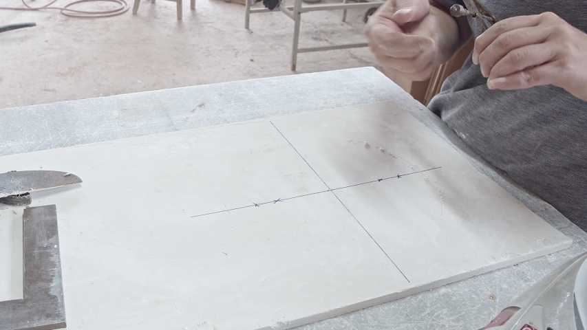 Woman worker working on gypsum sheet with metal compasses.Drawing a circles.