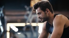 smiling sportsman talking on smartphone in gym