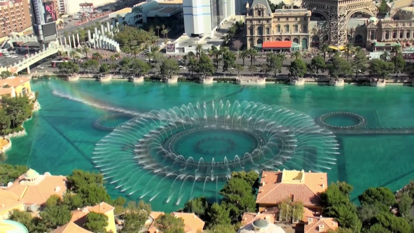 Las Vegas, Nevada, United States 8 october, 2019: luxury Bellagio fountains show on a sunny day with the Eiffel Tower in the background and blue sky. View of the Las Vegas Strip during the day.