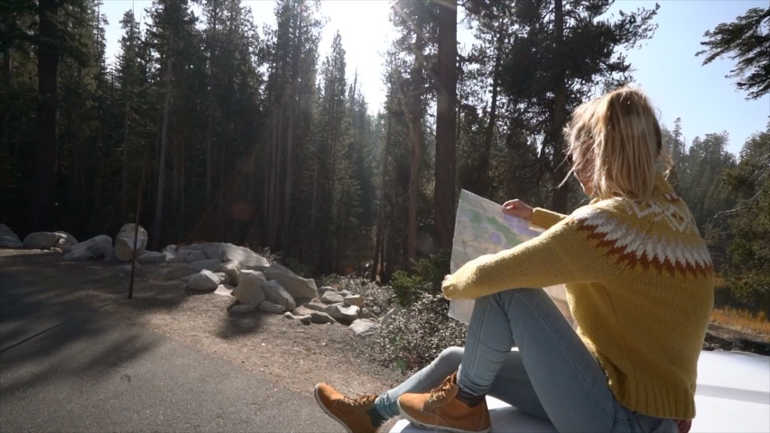 Road trip concept; Woman sitting on vehicle