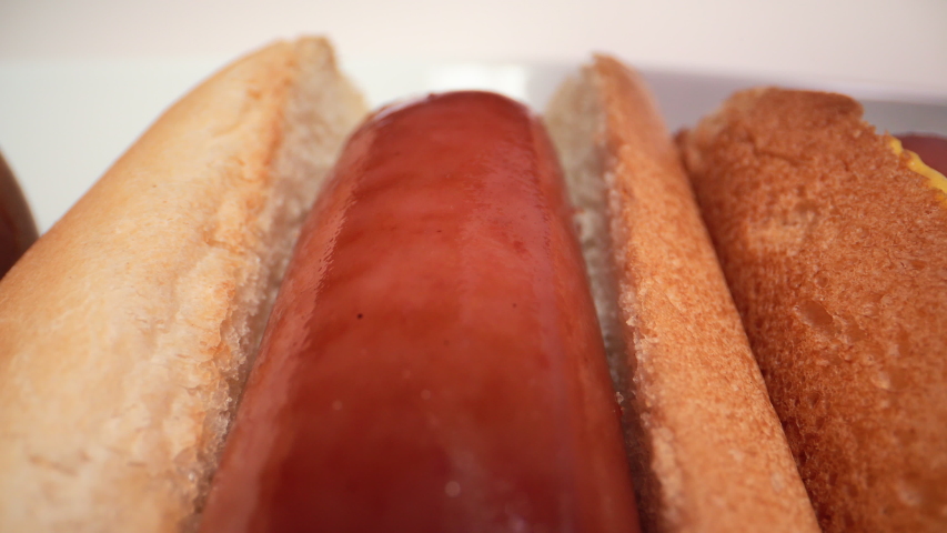 Extreme macro of beef hot dogs with mustard being squeezed on it.  Royalty-Free Stock Footage #1038665474