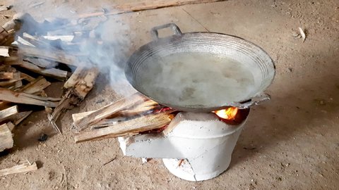 Set fire in the earthen stove to boil the water in the pan