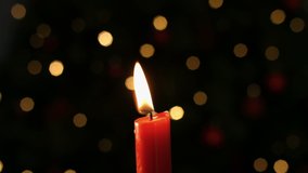 Animation of the words Frohe Weihnachten written in orange with lit candle and flickering lights in the background - Powered by Shutterstock - Get 15% off with code: PIKWIZARD15