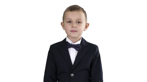 Little boy in a costume with a bow tie walking on white background.