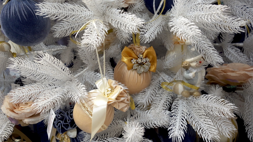 White christmas tree decorated with beautiful balls with bows and other toys in 4K.