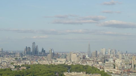 Aerial establishing shot of Buckingham Palace set against London skyline