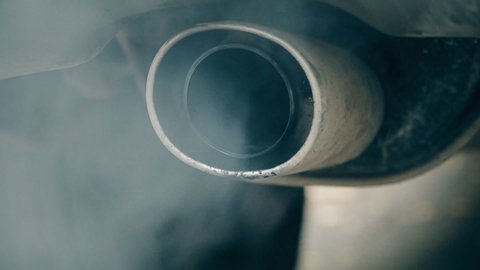 Smoke coming out of the exhaust pipe of a car.
