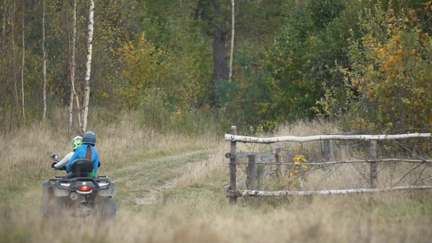couple riding a quad bike on a dirt road