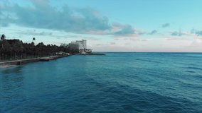 Aerial drone footage of Honolulu, Hawaii. Beautiful real estate, buildings in the city. Palm trees, ocean and beach.