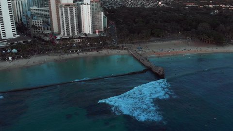 Aerial drone footage of Honolulu, Hawaii. Beautiful real estate, buildings in the city. Palm trees, ocean and beach.