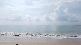 Landscape view of the white sea sand beach in summer daytime with some wave and wind blowing in Phuket, Thailand - in slowmotion 4k UHD video