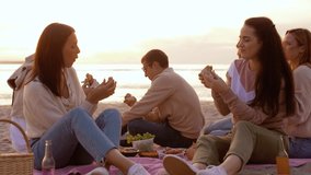 friendship, leisure and fast food concept - group of happy friends eating sandwiches or burgers at picnic on beach in summer - Powered by Shutterstock - Get 15% off with code: PIKWIZARD15