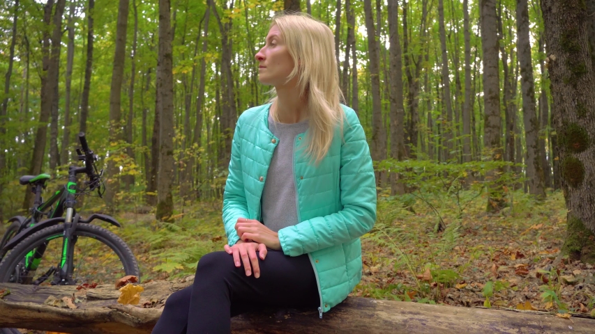 woman sits in park on background of bicycle, Autumn, bouquet of leaves.