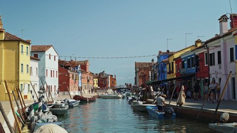 BURANO - JULY 14: Real time establishing shot of a canal with colorful houses on the island of Burano in Italy. Burano island is famous for its colorful houses, July 14, 2019 in Burano, Italy.