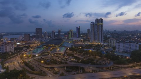 Aerial time lapse of Johor Bahru cityscape at sunset with busy traffic on elevated highway in South of Malaysia. Pan down motion timelapse. Zoom in motion timelapse. Full HD.