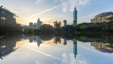 Beautiful Time lapse sunrise view of Taipei cityscape at dawn with reflection of Taipei 101 skyline by a lake in a public city park at dawn in Taiwan. Full HD.