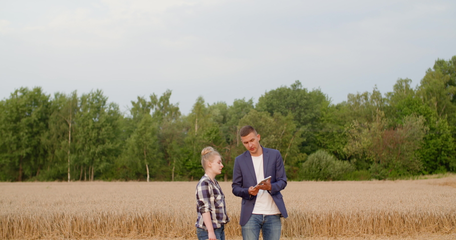 Young Farmers Discussing At Wheat Field